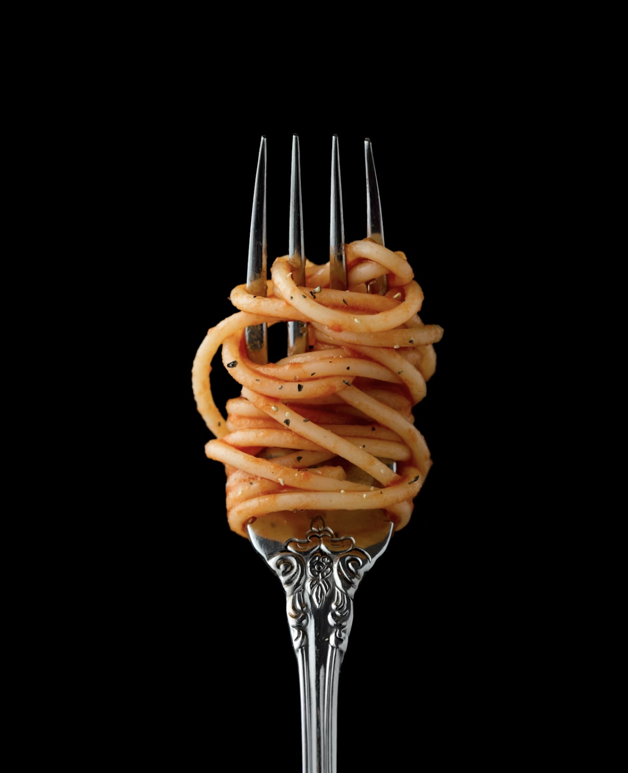 フォークにくるっと巻かれたトマトソースのスパゲッティ。シンプルでおしゃれな一枚。