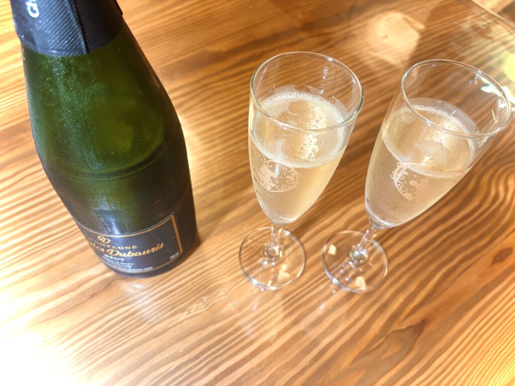 グラスに注がれたスパークリングワインで乾杯。大人の記念日ディナーを彩る、泡のごちそう。