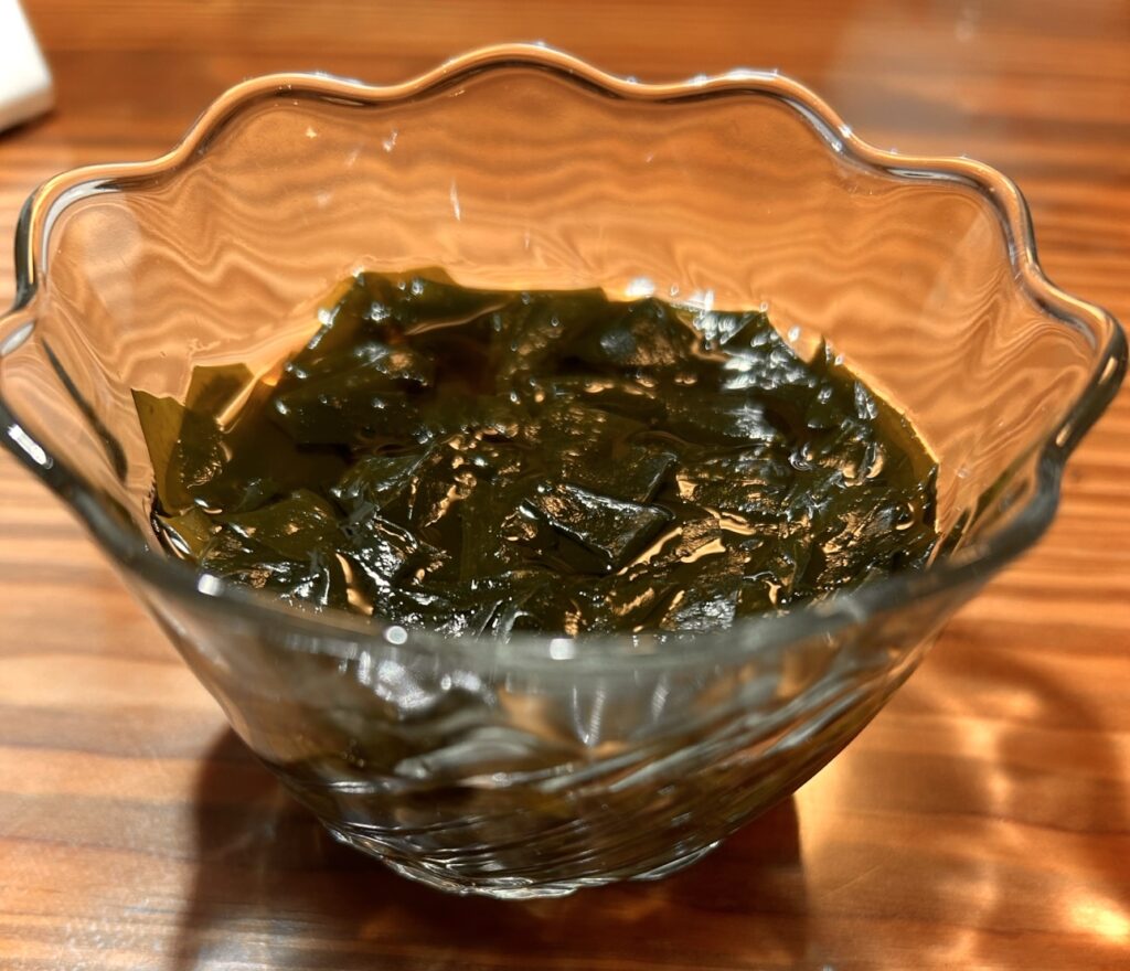 ガラスの器に盛り付けられた、わかめの酢の物。つやのあるわかめが涼しげな一品。」