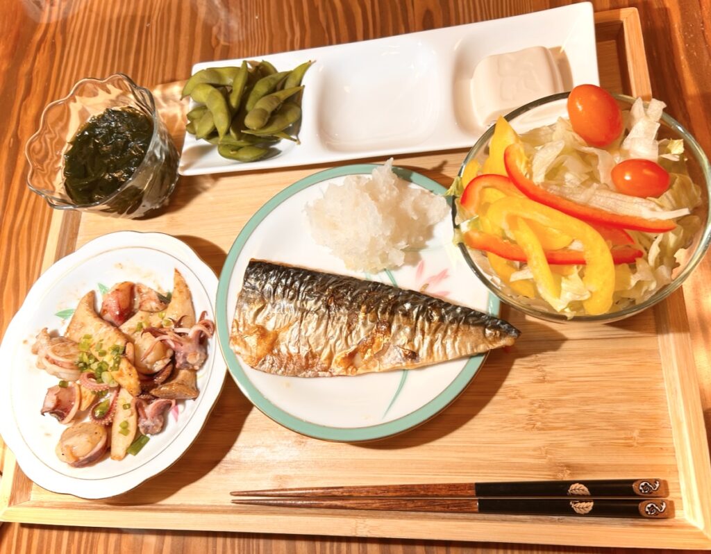 塩サバを中心に、サラダ、イカと厚揚げの炒め物、わかめ、枝豆を添えた和風定食のワンプレート。