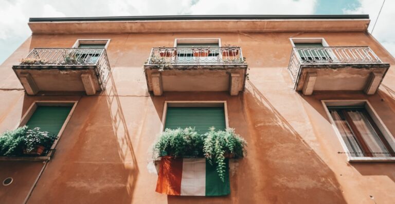 ベランダにイタリア国旗が飾られた、オレンジ色の外壁の建物