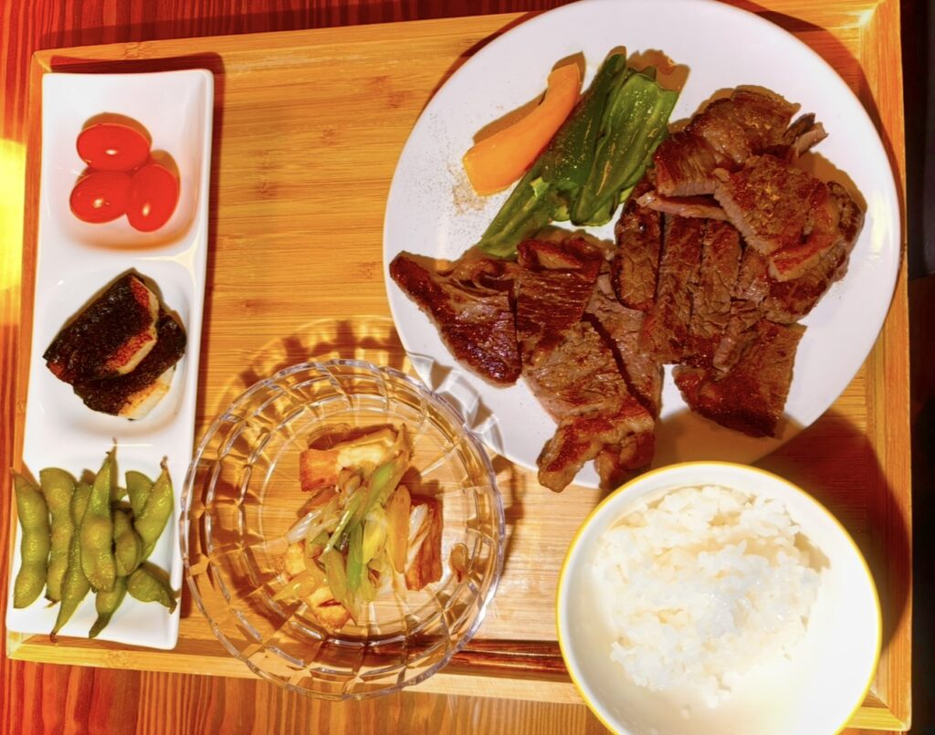 分厚く焼かれたステーキと焼き野菜、白ごはんの豪華な晩ごはんプレート