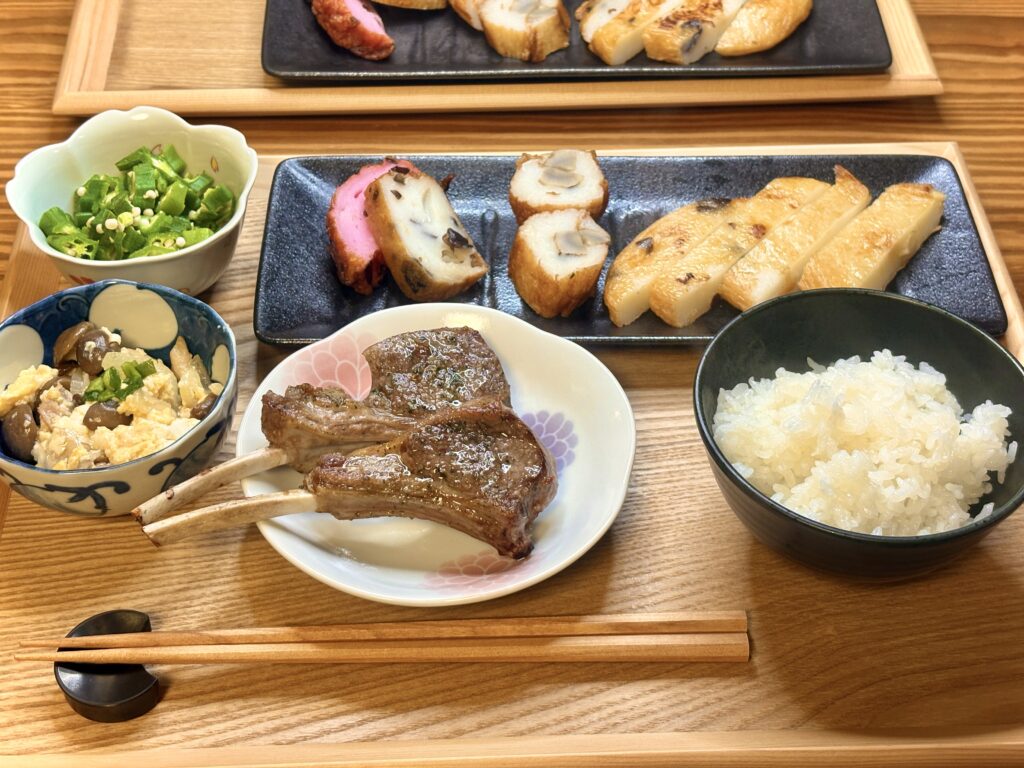 ラムチョップをメインに、きのこと豆腐のチャンプルー、オクラのおひたし、有名店のさつま揚げ盛り合わせ、白ごはんを並べた和洋折衷の夕食セット。旦那キッチンらしく、手作りと買ってきたものをうまく組み合わせた食卓