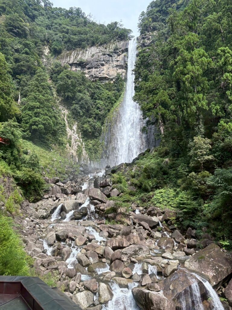 和歌山県にある日本三大名瀑のひとつ、那智の滝。高さ133メートルの一本の滝が岩肌を流れ落ち、下流には大きな岩と清流が広がっている。周囲は深い緑の森に囲まれている。