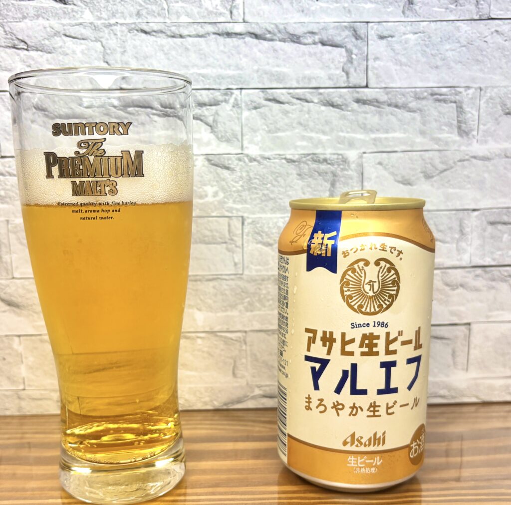 アサヒ生ビール〈マルエフ〉の缶と、サントリー・プレミアムモルツのグラスに注がれたビール。異なるメーカーの組み合わせがユーモラスで、おうち居酒屋らしい自由な一杯。