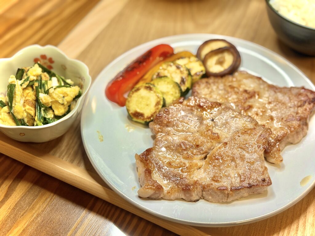 香ばしく焼いたトンテキとパプリカ・ズッキーニ・しいたけのグリル、予定外に加わったニラ玉を添えたボリューム満点の晩ごはんプレート