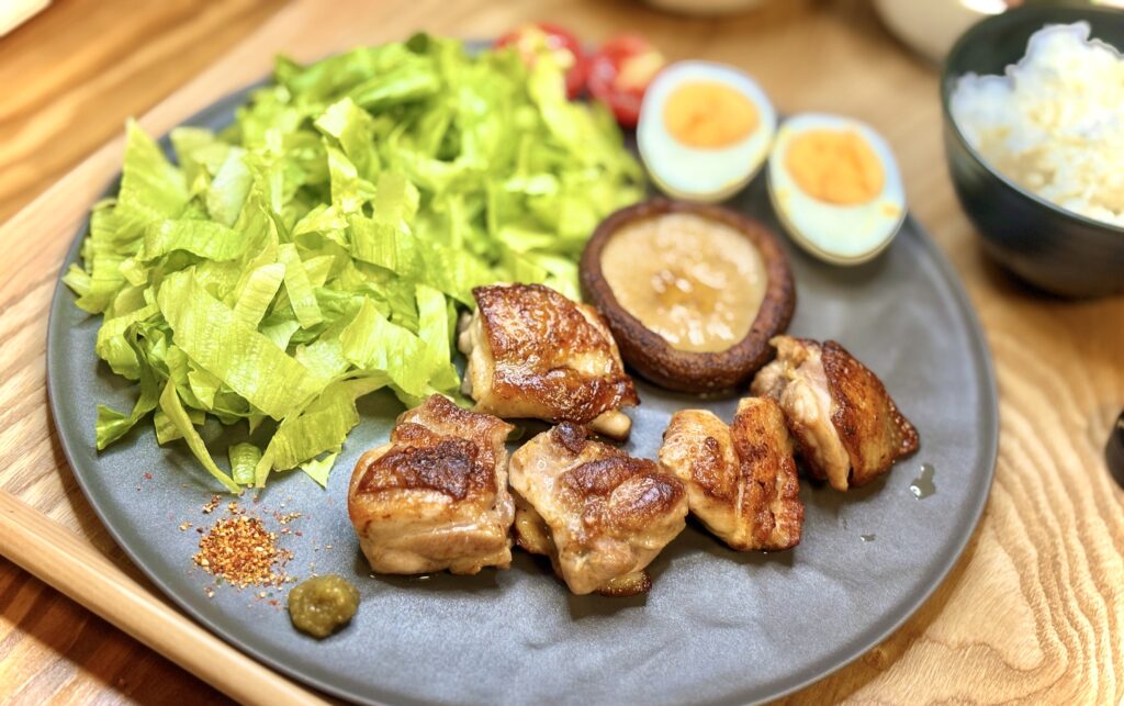 こんがり焼き上げた名古屋コーチンと肉厚な椎茸ステーキ。横にはシャキシャキレタスと彩り野菜、ゆず胡椒が添えられている