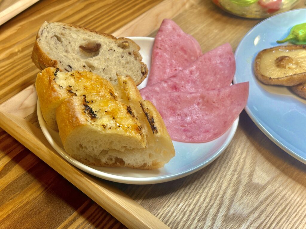 小皿に盛られたビゴのメイプルフランスと渋皮栗フランスパン、ビアソーセージハム