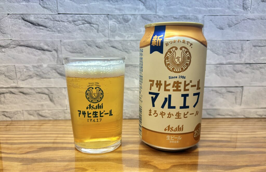 アサヒ生ビール〈マルエフ〉の缶。白と金を基調にしたレトロ感のあるデザインで、「おつかれ生です。」の文字が入っている。木目調のテーブルに置かれている。