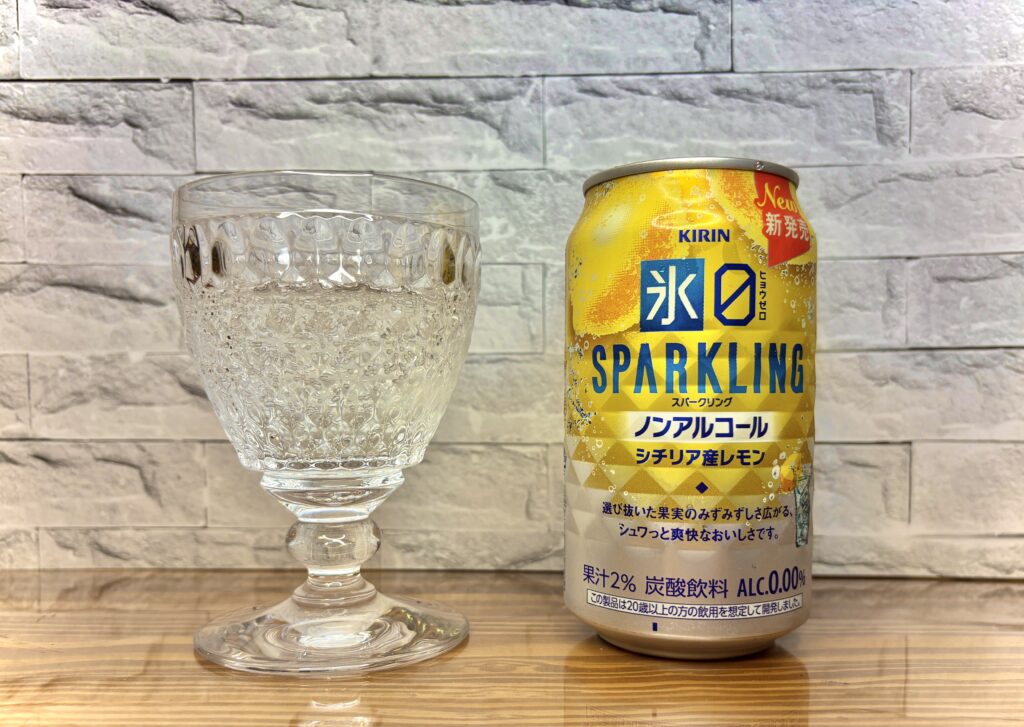 ガラスのグラスに注がれた炭酸がきらめく「氷結ZERO スパークリング シチリア産レモン」。横には黄色い缶が並び、爽やかなレモンのデザインが映える。食卓に清涼感を添えるノンアルコールの一杯。