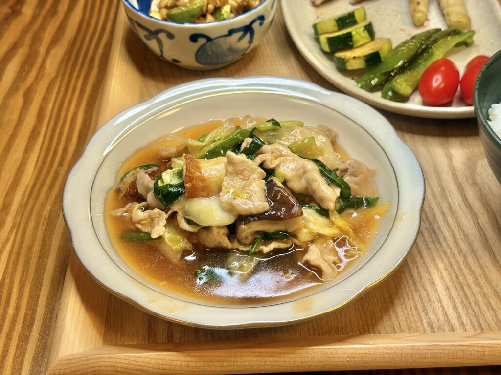 白菜と豚肉、しいたけ、青菜をとろみのあるあんで煮込んだ白菜の旨煮。照りのあるタレが食欲をそそる、家庭のあたたかいおかず。