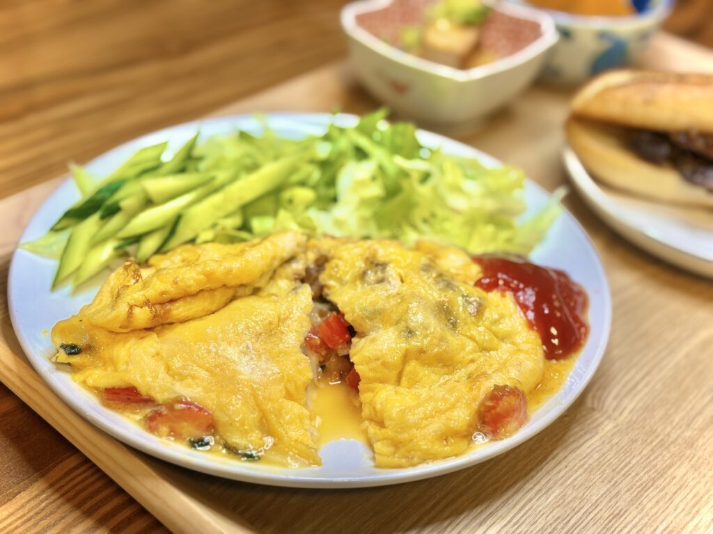 トマトとバジルを包んだふわとろオムレツ。ケチャップを添えて、レタスときゅうりのサラダを合わせた彩りプレート。