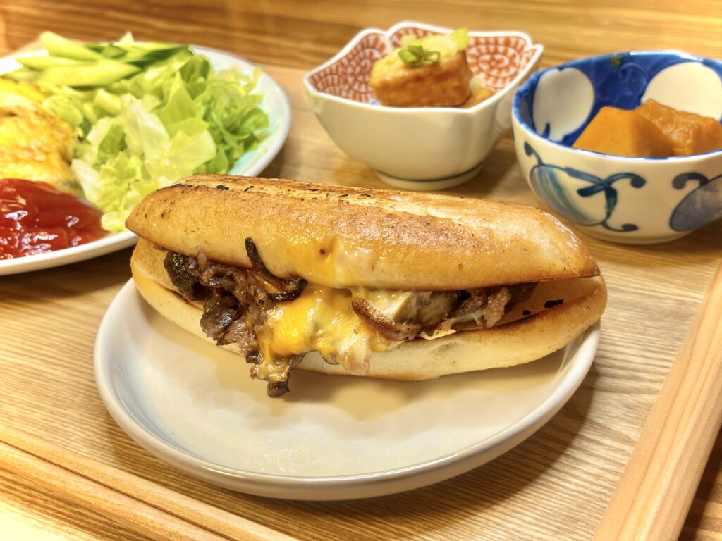 フィリーズチーズステーキサンド。ジューシーな牛肉ととろけるチーズをバゲットで挟んだ、旦那キッチン流のボリューム満点メインディッシュ。