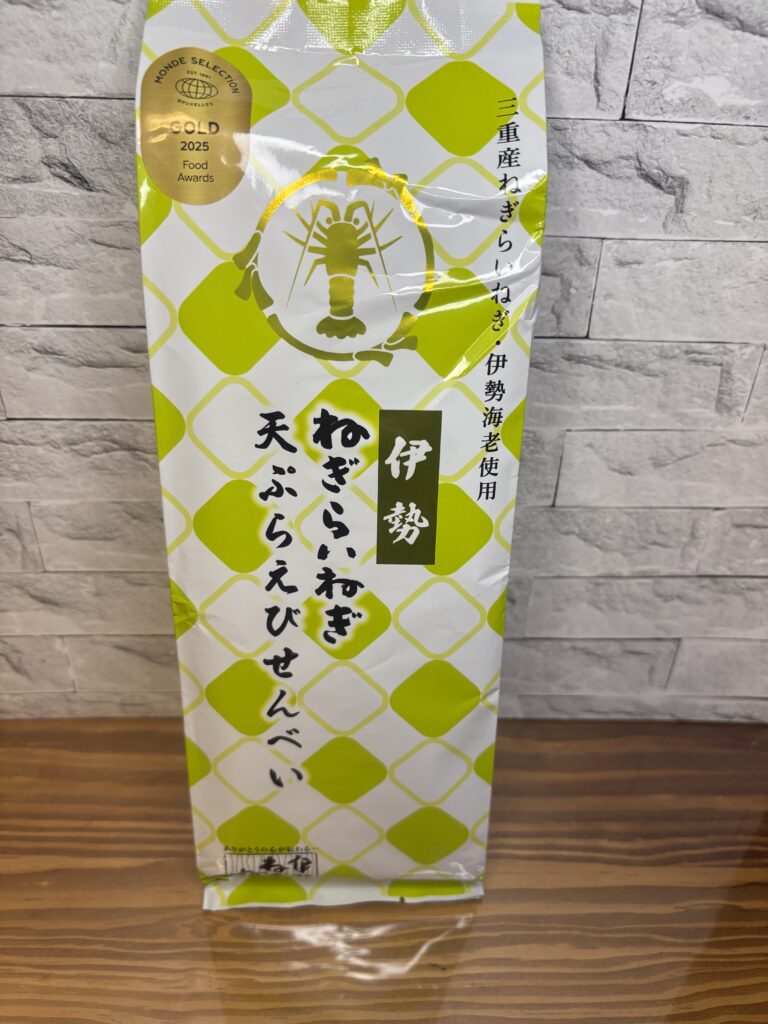 「伊勢ねぎらいねぎ天ぷらえびせんべい」のパッケージ写真。
2025年モンドセレクション金賞を受賞した金色マークが輝き、
爽やかな黄緑色のデザインが印象的。三重産ねぎと伊勢海老を使用した贅沢なえびせんべい。