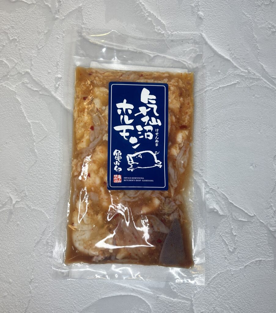 三重県亀山市の名物『亀山ホルモン』のパッケージ。味噌ダレで漬け込まれたホルモンが袋に詰められ、青いラベルに白文字で商品名が書かれている。