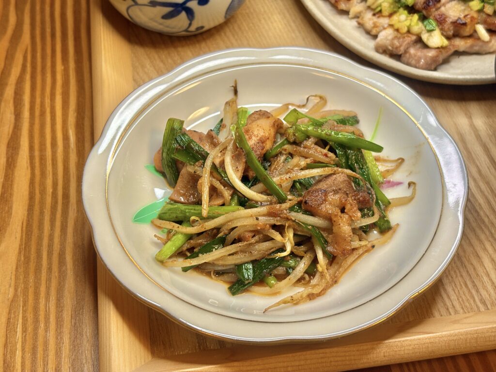 三重名物の亀山ホルモン炒め。甘辛い味噌ダレが絡んだホルモンに、シャキシャキのもやしとニラが彩りよく盛りつけられた一皿。