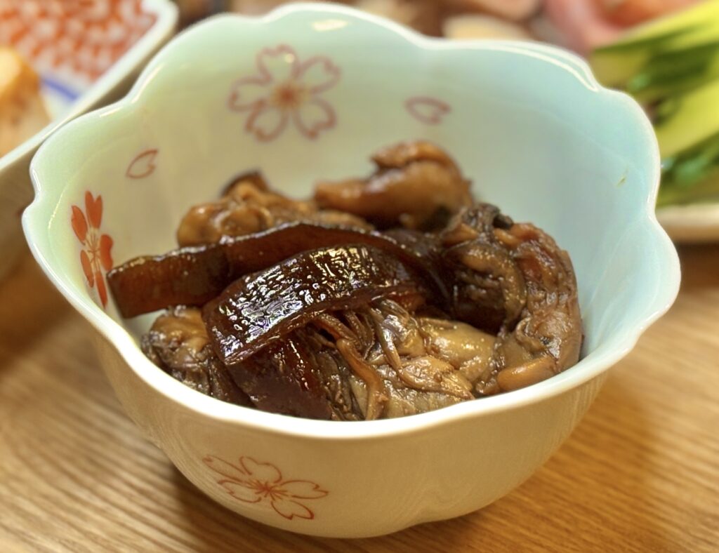 煮汁がしっとり絡んだ牡蠣佃煮が小鉢に盛られている。茶色く照りのある牡蠣と昆布が美しく、食欲をそそる和のお惣菜。