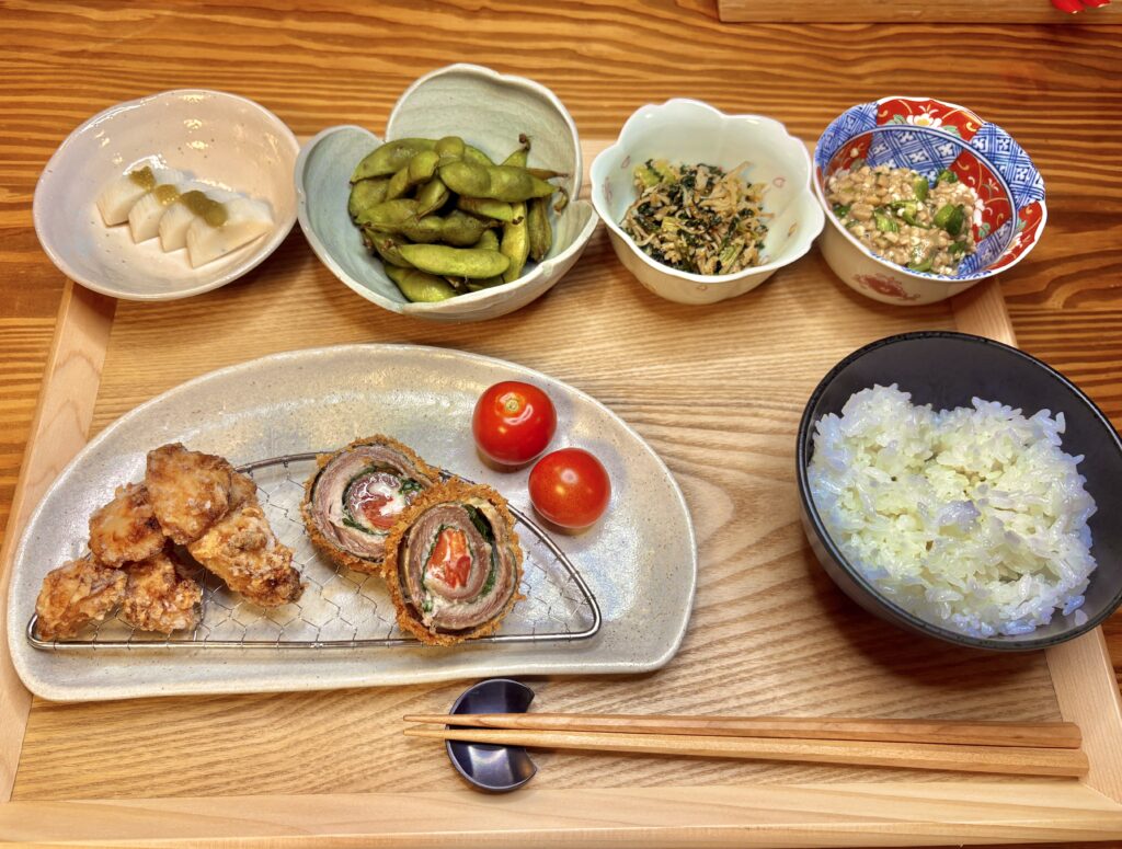秋刀魚のシソチーズトマト巻きと唐揚げをメインにした和定食。枝豆や納豆、ひじきの和え物、小鉢料理が並ぶ秋の食卓。