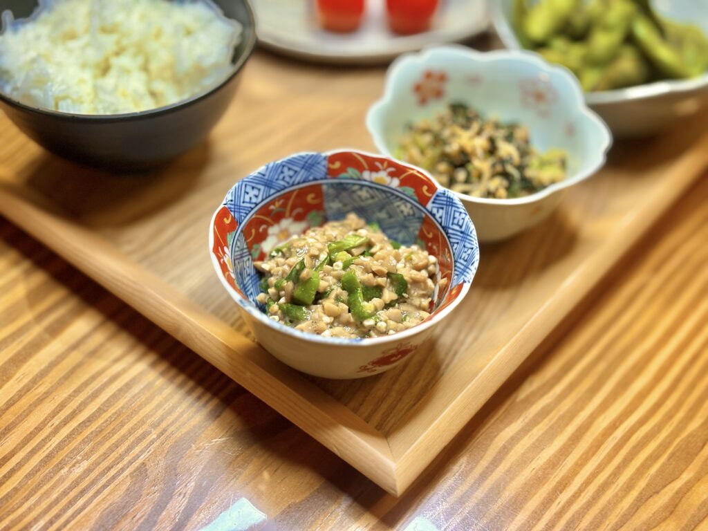 「刻んだおくらを混ぜた納豆。赤と青の模様が入った和柄の小鉢に盛り付けられている。」
