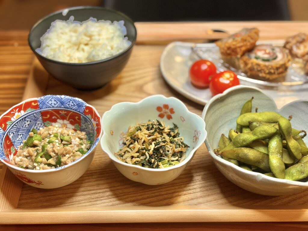 しらすと小松菜の胡麻炒め。白と緑の彩りがきれいな和え物が、花柄の小鉢に盛り付けられている。