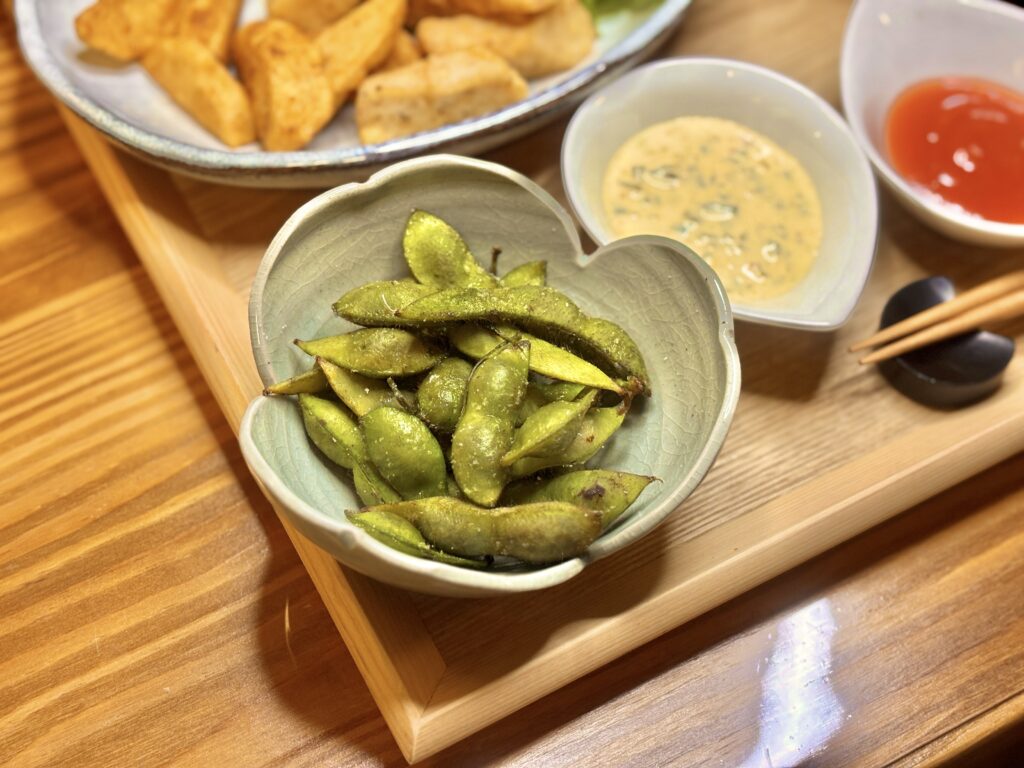 丹波篠山産の枝豆を器に盛り付けた一皿。香ばしく焼き上げられた枝豆が、木のトレイの上で秋の味覚を感じさせる。