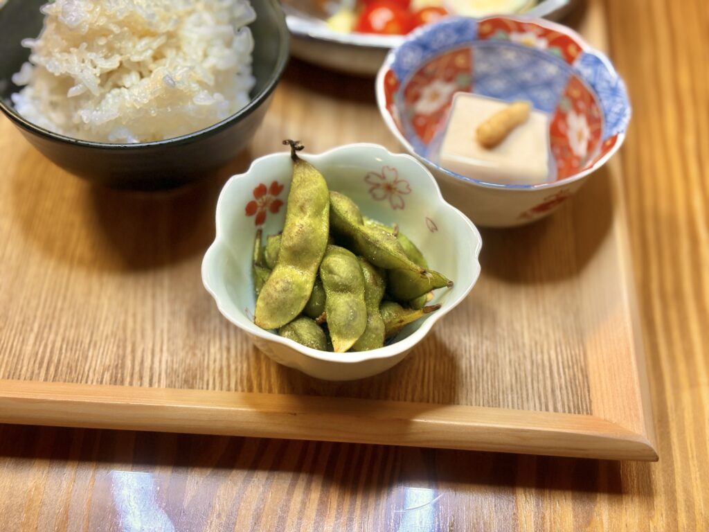 旦那キッチンの食卓。丹波篠山の黒枝豆と、しょうがをのせた冷奴、ふっくら炊きたてのごはん。木の温もりを感じる和の晩ごはん。