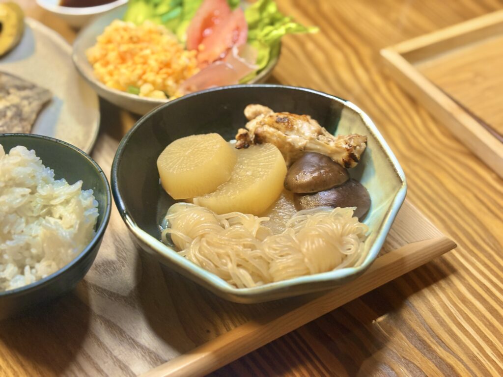 大根、手羽先、しいたけ、白滝を盛り付けた和食の煮物料理