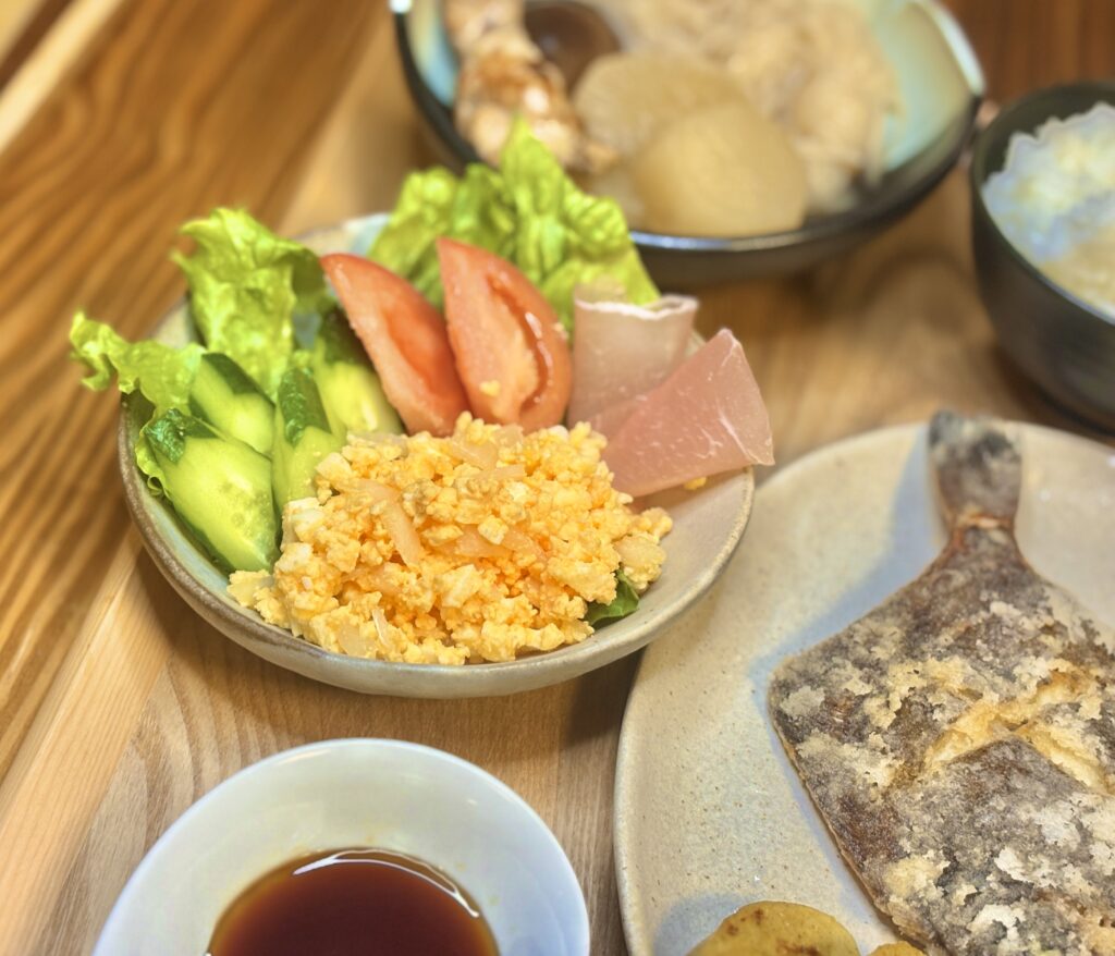 卵サラダと生ハム、きゅうり、トマトを盛り合わせた彩りの良いサラダの写真