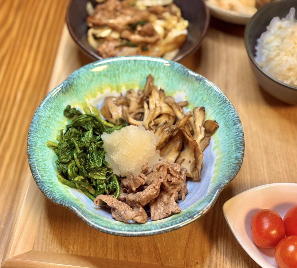 春菊と舞茸、牛肉の炒め物に大根おろしを添えた彩りの良いお皿のアップ写真
