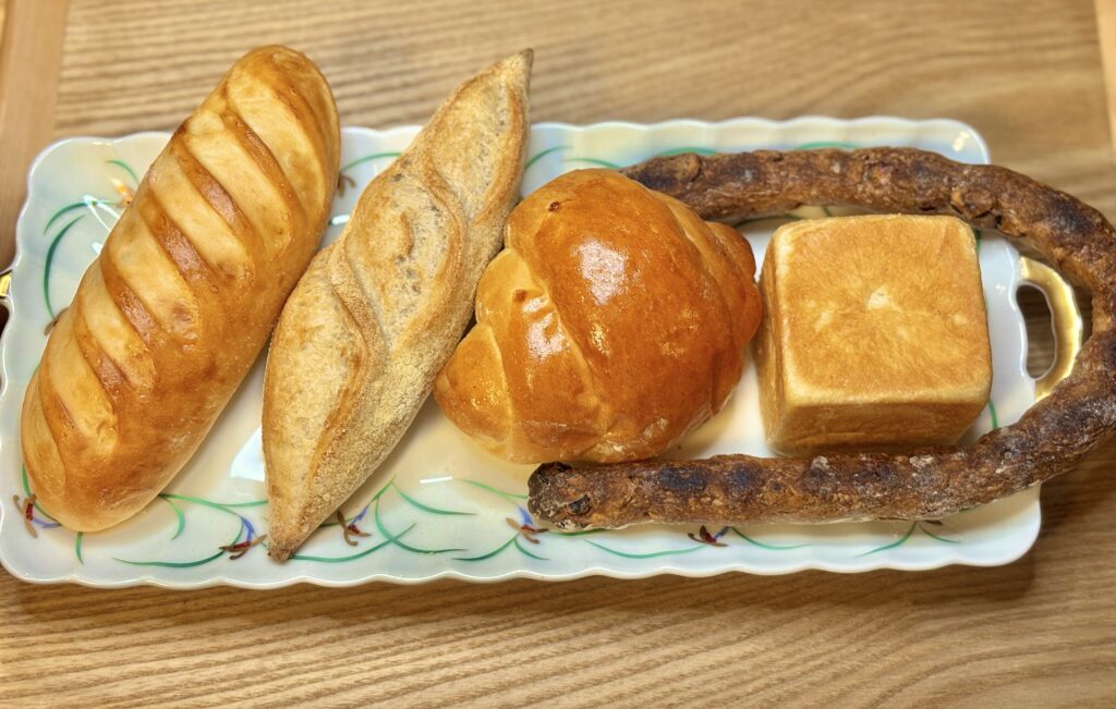 細長いパンから四角いパンまで、食卓に並んだトリコのパン4種類の盛り合わせ。