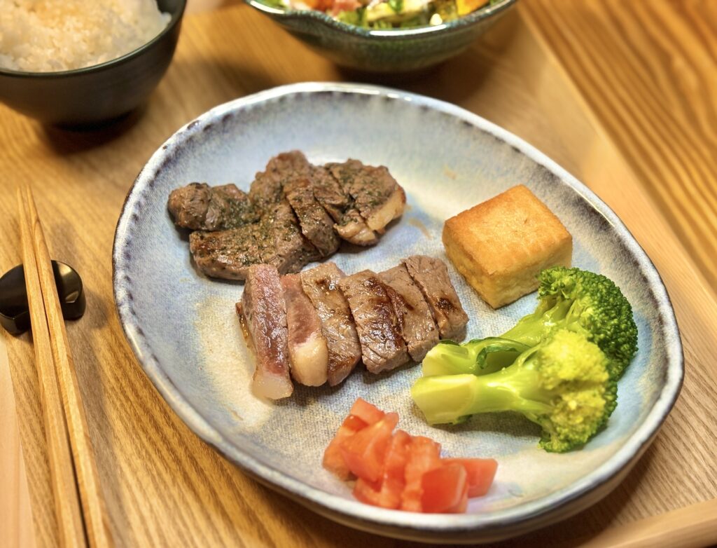 和牛とラム肉のステーキ盛り合わせ。焼き加減が分かる断面と付け合わせの厚揚げ・ブロッコリー"
