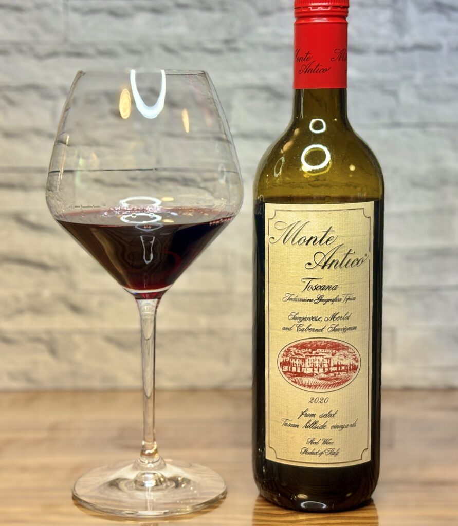 モンテ・アンティコと赤ワイングラスを並べたトスカーナ赤ワインの写真
