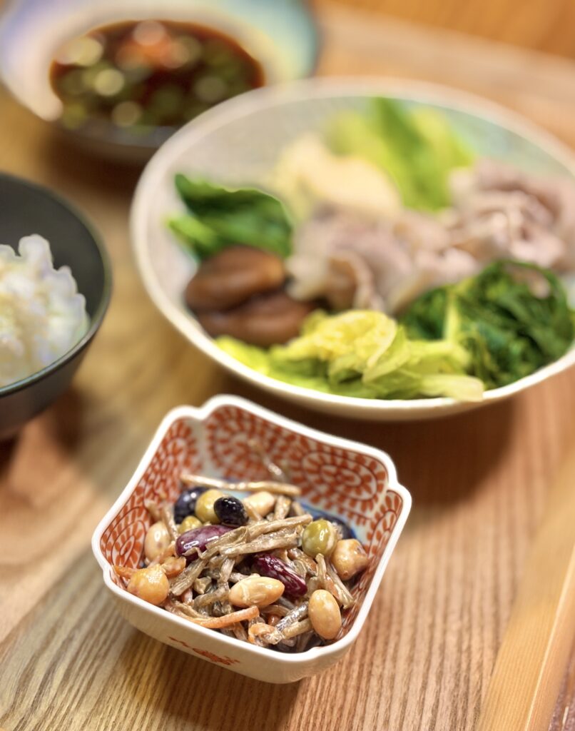 豆とごぼうのサラダ小鉢を手前に、奥に豚しゃぶや野菜のお皿が並ぶ和食献立の写真