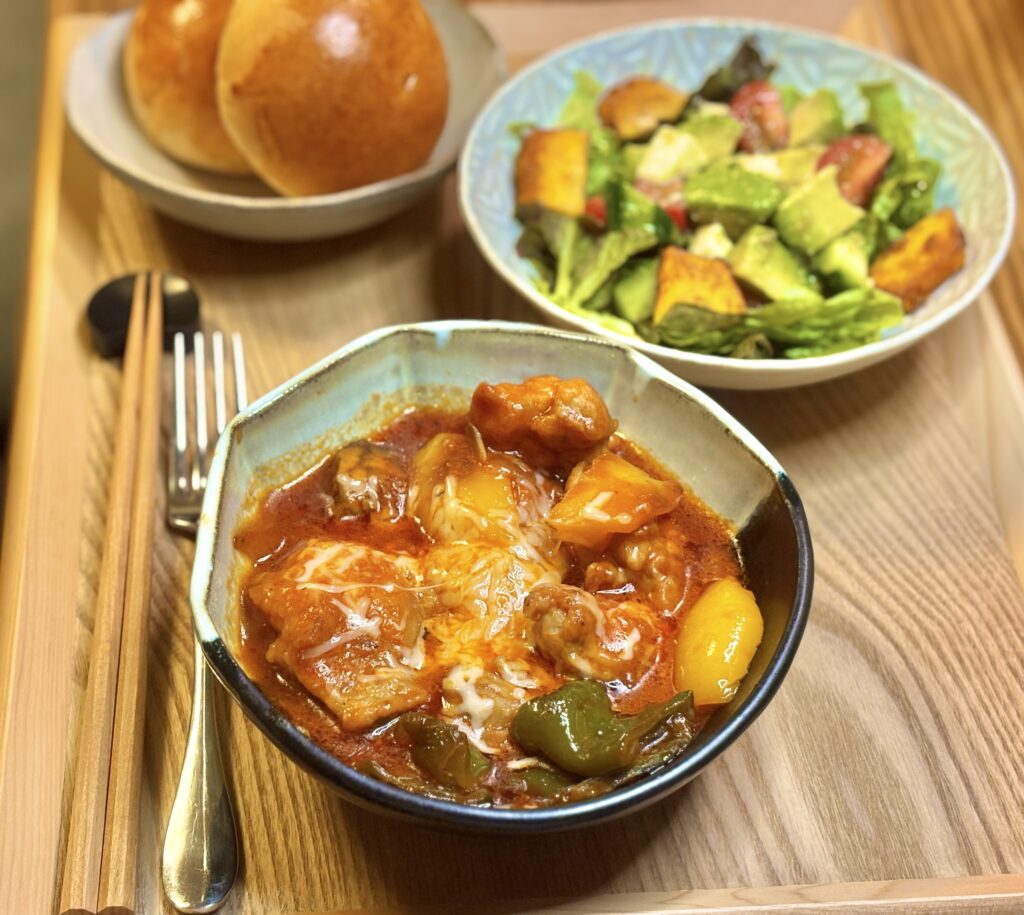 チーズがとろけた鶏肉のトマト煮。パプリカと野菜がゴロッと入った濃厚煮込み料理のアップ