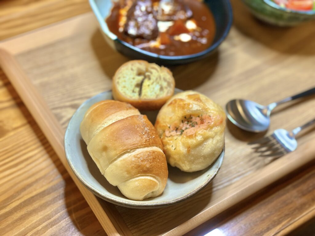 「カンテグランデの塩パン、明太チーズパン、ガーリックフランスを盛り合わせたプレート。ビーフシチューと一緒に楽しむ旦那キッチンのおうちパンセット」