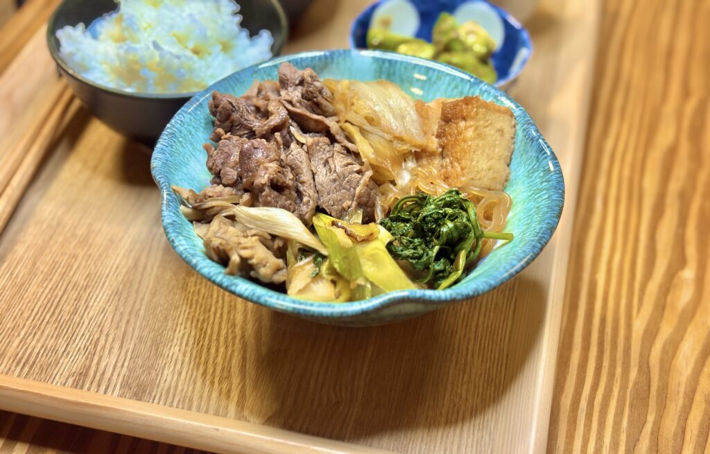 牛肉、白菜、ねぎ、しらたき、厚揚げ、春菊を甘辛く煮込んだすき煮。ご飯と一緒に楽しむ旦那キッチンの和食メインディッシュ