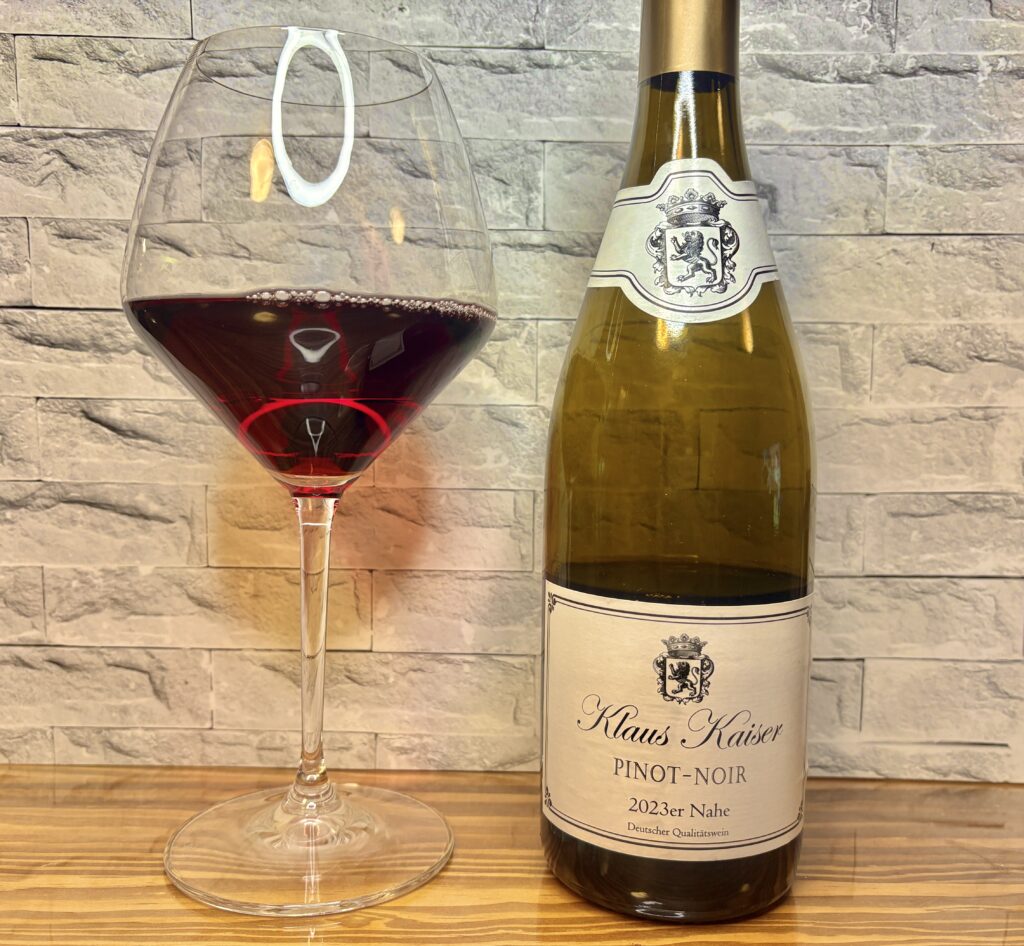 グラスに注がれた赤ワインと、ドイツ・ナーエ地方の「Klaus Kaiser ピノ・ノワール 2023」ボトル。透明感のあるルビー色が美しく、エレガントなラベルデザインが印象的な一枚。