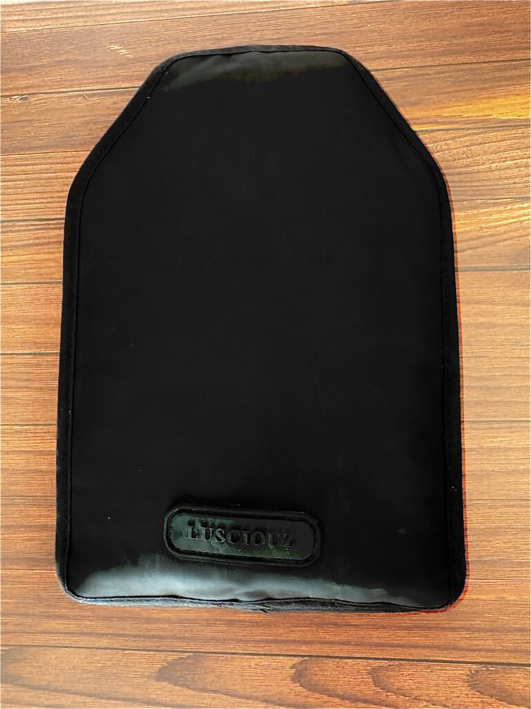 黒いボトルクーラーを装着した白ワインボトル。テーブルの上に立てられ、背後には白いレンガ調の壁。冷たさをキープしながら、見た目もスマートな印象のワインクーラー。