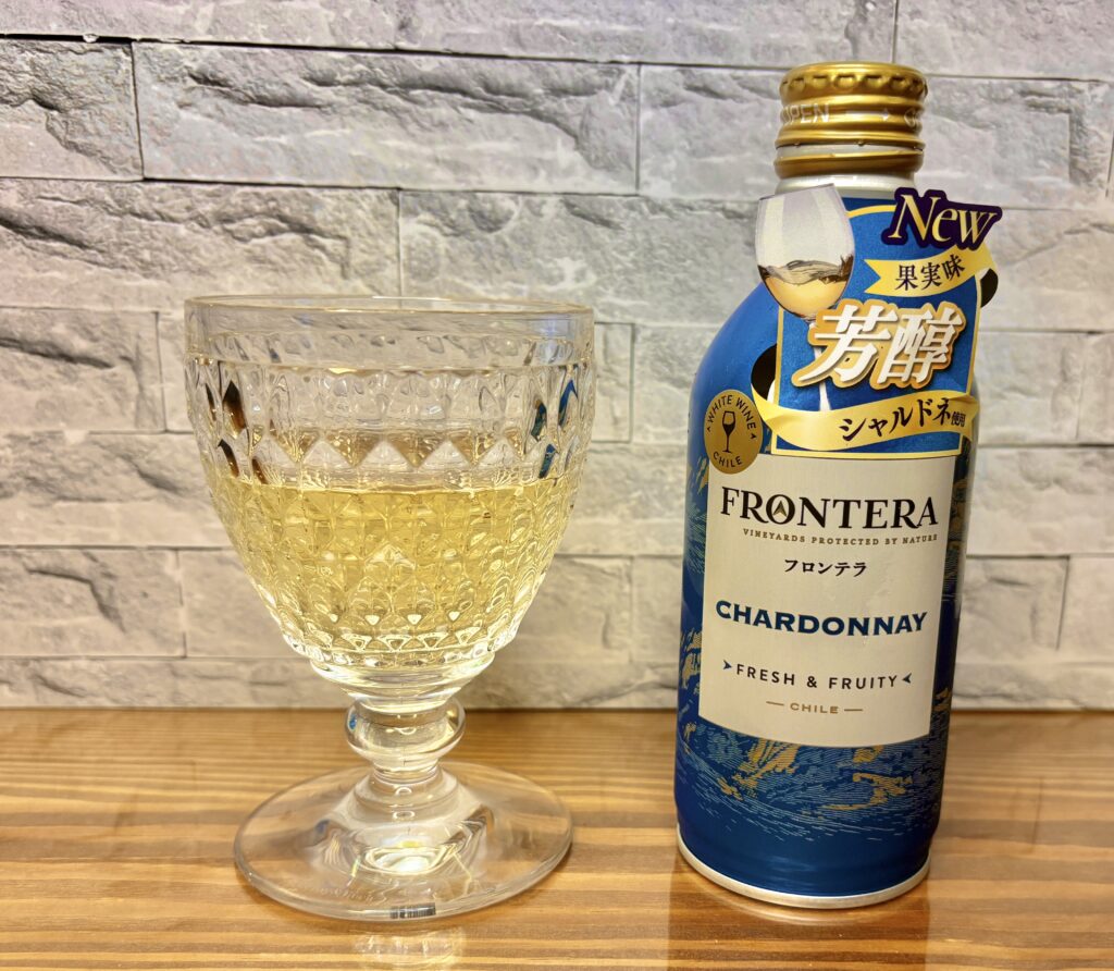 フロンテラの芳醇シャルドネをグラスに注いだ様子。金色に輝く白ワインと、青いボトルのラベルが並ぶテーブルの上の乾杯シーン。

