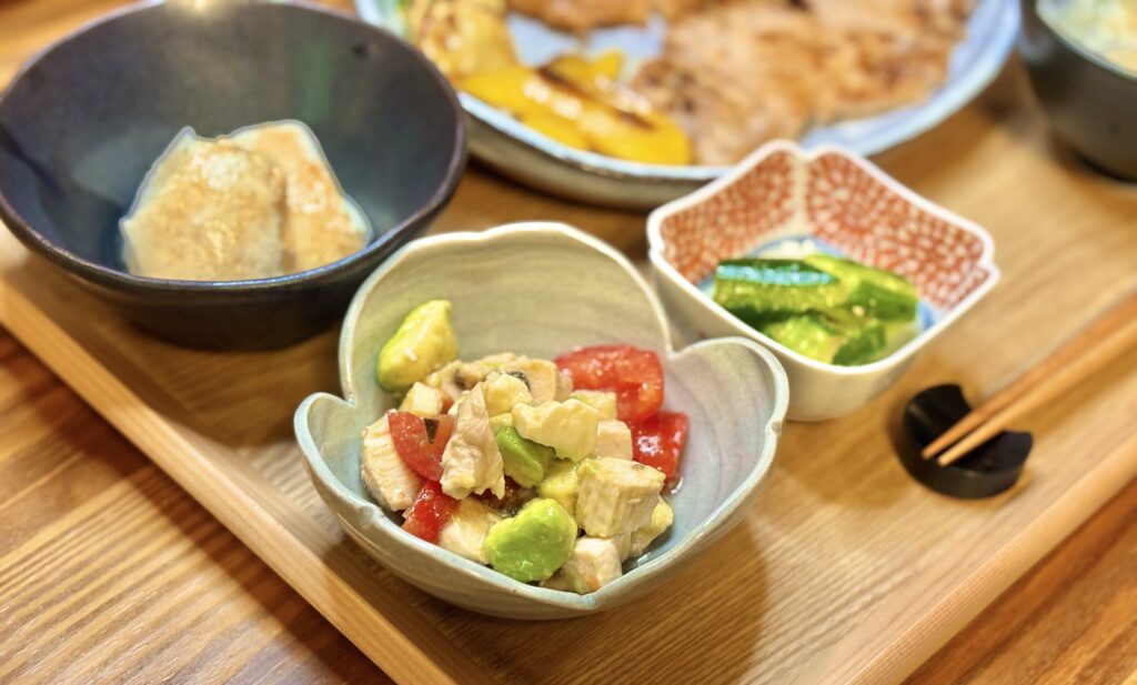 鶏胸肉とトマト、アボカド、チーズをピエトロドレッシングで和えたサラダ。彩り豊かでクリーミーな味わいの小鉢料理。