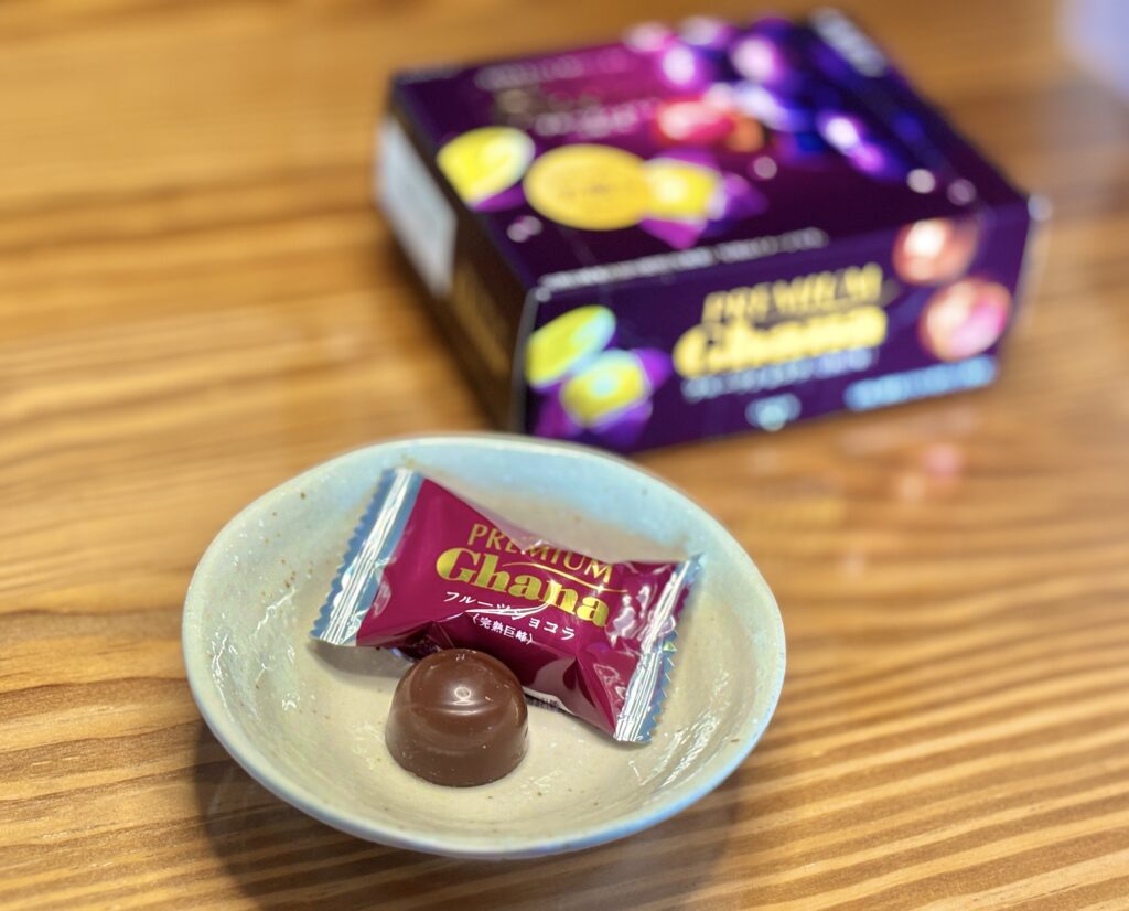 ロッテ プレミアムガーナ〈完熟巨峰〉のチョコレートを小皿に盛り付けた様子。奥には紫のパッケージ箱があり、上品で華やかな雰囲気。