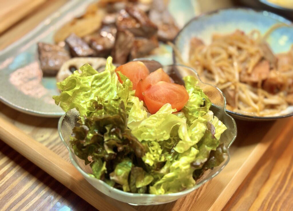 透明なガラスのボウルに入ったレタスとトマトのサラダ