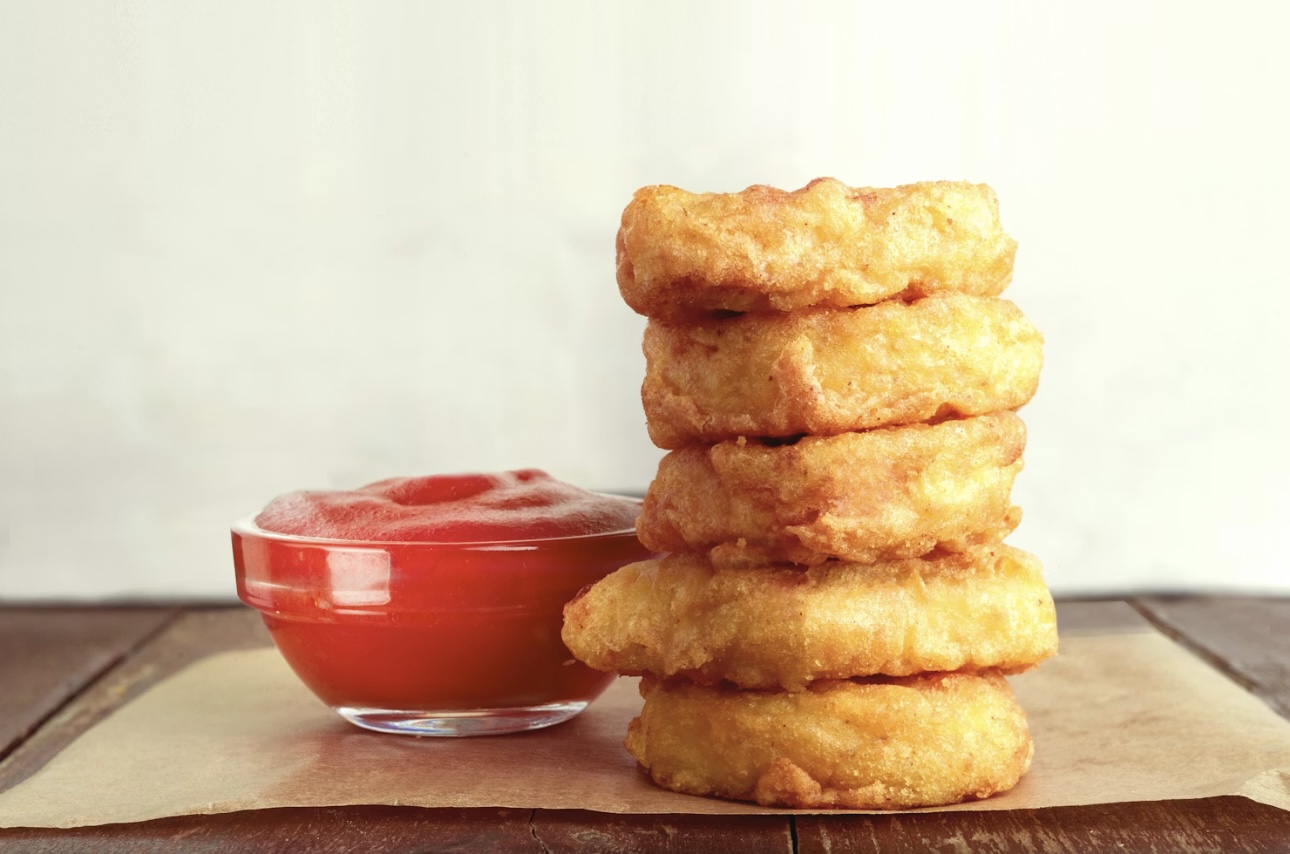 ふわっと揚がったチキンナゲットがきれいに積み重なり、横にはディップ用のケチャップが添えられた写真。