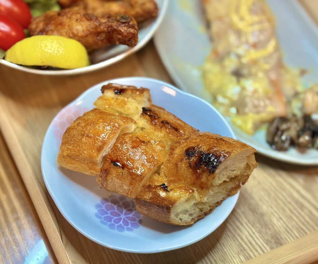 表面がこんがり焼け、メイプルとバターがしみ込んだバゲットが皿に盛られているアップ写真。