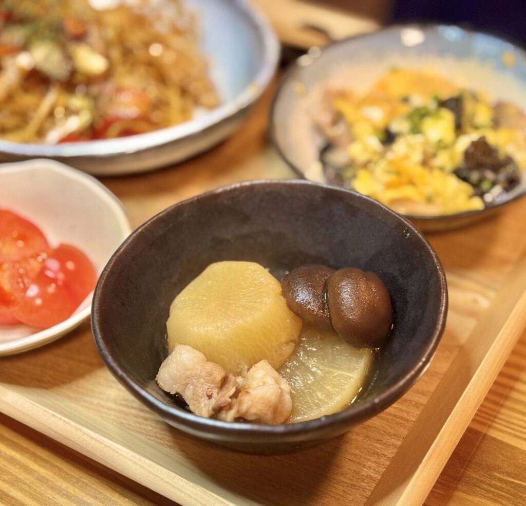 味がよく染みて飴色になった大根と、豚バラ肉と椎茸の煮物のアップ写真