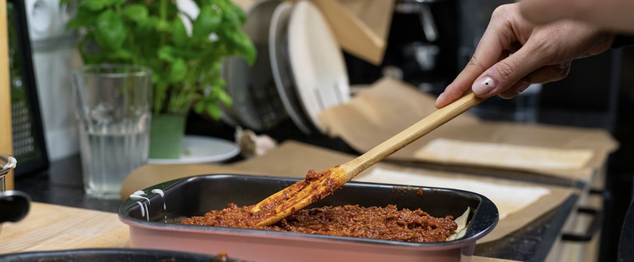 　木べらを使ってミートソースを広げてる