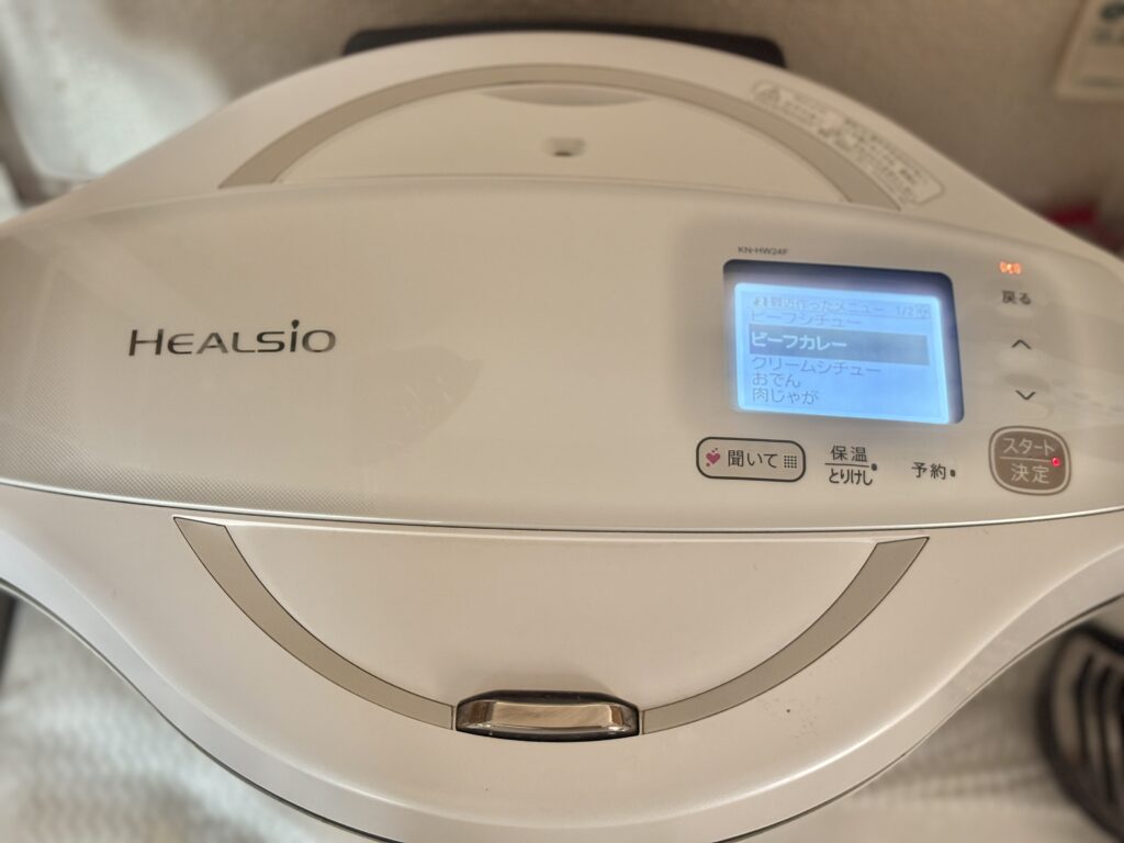 キッチンに設置されたホットクック本体の全体写真。前面にはHEALSIOのロゴと操作画面があり、調理家電としての存在感がある。