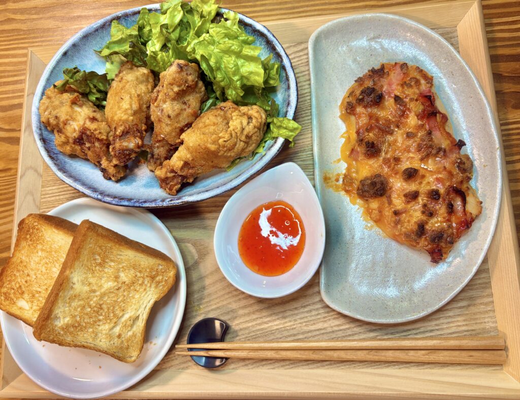 鶏胸肉を生地にしたピザ、フライドチキン、トースト、スィートチリソースをワンプレートに盛り付けた食卓風景