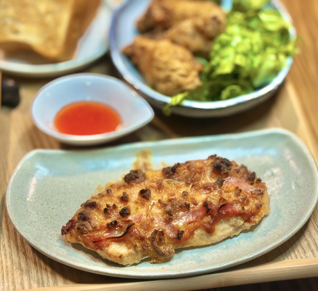 鶏胸肉を生地にして焼き上げたピザに、チーズとベーコンをのせたヘルシーな一品