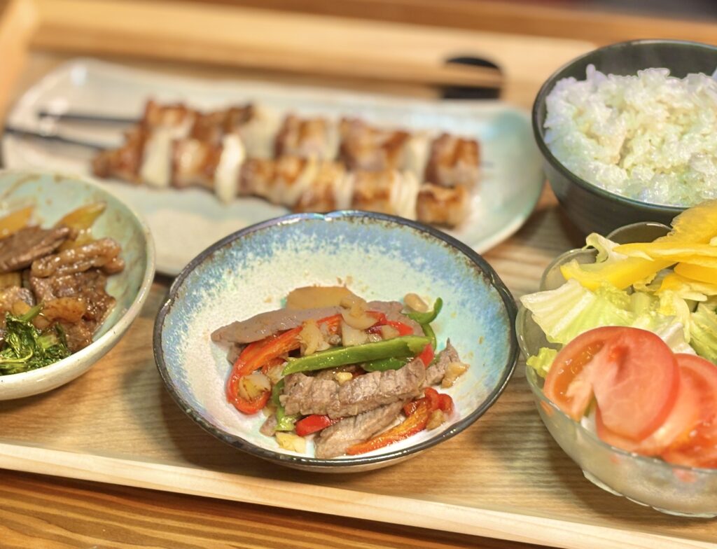 牛肉と赤ピーマン・緑ピーマンを使ったガーリック炒めを器に盛りつけた写真。香ばしそうな焼き色と野菜の彩りが食卓を明るくする副菜。